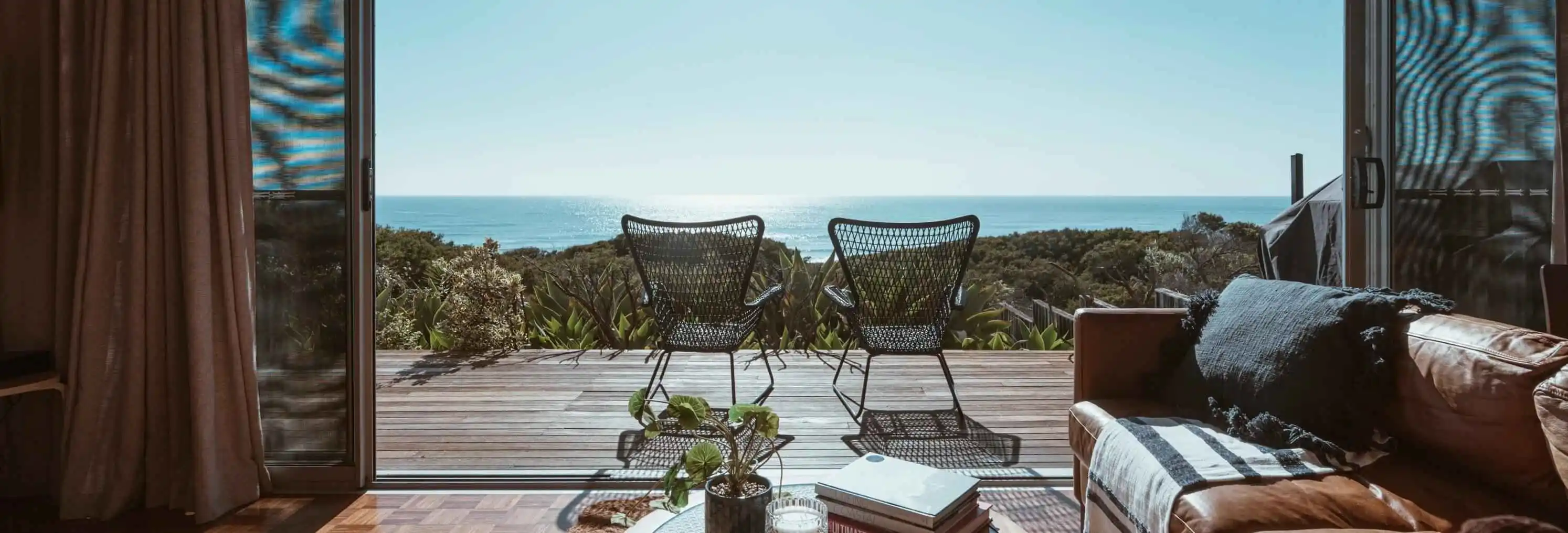 Two chairs on a seaside patio of a house