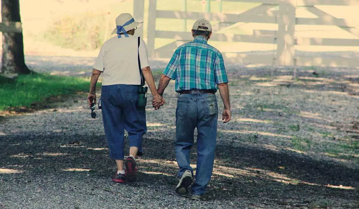 An old couple walking holding hands